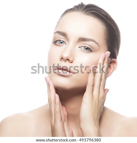 Beautiful face of young caucasian brunette woman with natural lips, make-up and blue eyes isolated on white. Touch her perfect skin. Studio portrait.