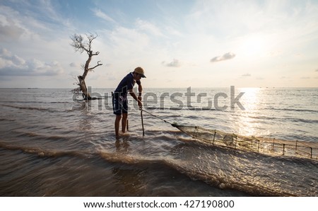 Tien Giang, Vietnam - May 01, 2016: A man setting up a trap to catch crabs, lobsters, shrimps, fishes on the pacific ocean in the early morning.