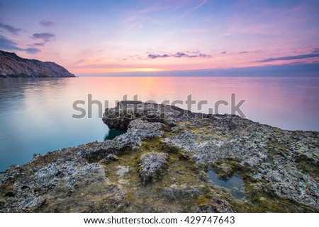 Wonderful dawn over large rock in calm waves at Nui Chua national park, Ninh Thuan Province, Viet Nam, one of amazing landscape in Vietnam, masterpiece place for travel.