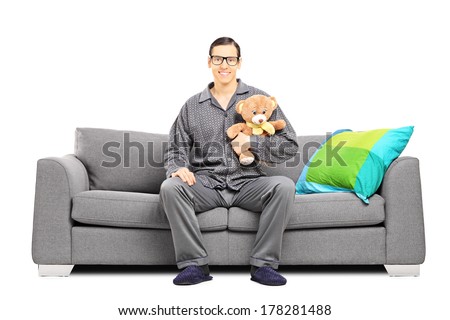 stock-photo-young-man-in-pajamas-sitting-on-a-sofa-and-holding-a-teddy-bear-isolated-on-white-background-178281488.jpg