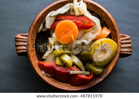 Mix of Turkish Pickles with green tomatoes, red pepper, cucumber and carrot in a bowl.