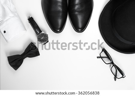 Men's accessories men's shoes, watches, glasses, bow tie, sleeve shirt and hat/Black and white minimalistic composition on a white background. Classic men's accessories. Top view