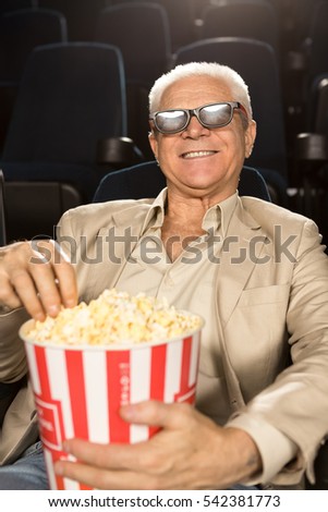 stock-photo-retirement-rocks-vertical-portrait-of-a-happy-senior-man-enjoying-a-d-movie-eating-popcorn-at-the-542381773.jpg