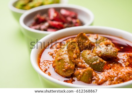 group photo of indian traditional  Mango pickle / aam ka achar, hari mirch achar / green chilli pickle, red chilli pickle / lal mirch ka achar, served in 3 white bowls, selective focus