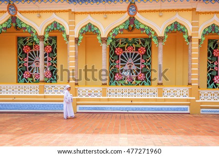 TAY NINH, VIETNAM - NOV 10, 2014:Cao Dai temple area and meditating followers of the Cao Dai religion in the temple Cao Dai