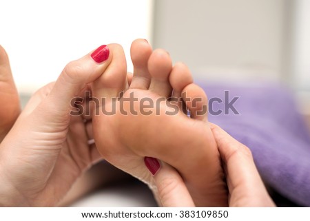 Người phụ nữ có một điều trị chân tại một spa hay thẩm mỹ viện với pedicurist xoa bóp bàn chân.
