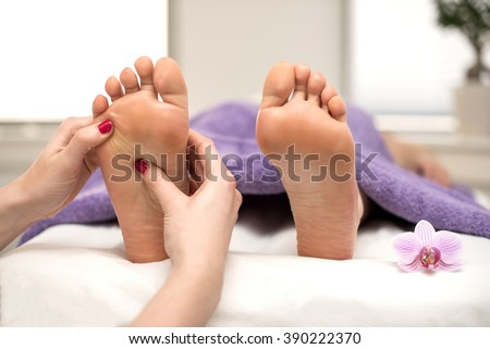 Người phụ nữ có một điều trị chân tại một spa hay thẩm mỹ viện với pedicurist xoa bóp bàn chân.