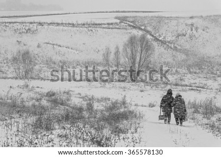 Black and white winter landscape with snow and two going down the road people Black and white winter landscape with snow and two going down the road people