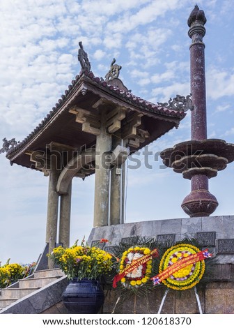 Flowers in the front against scarlet tiles and blue skies.