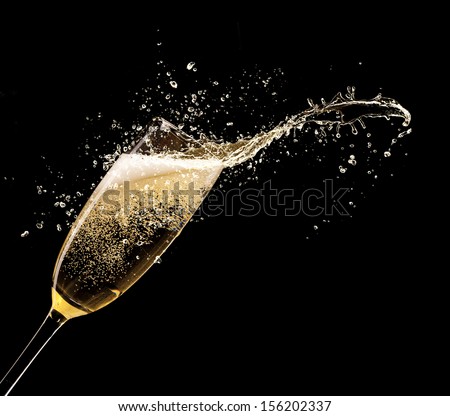 Glass of champagne with splash, isolated on black background
