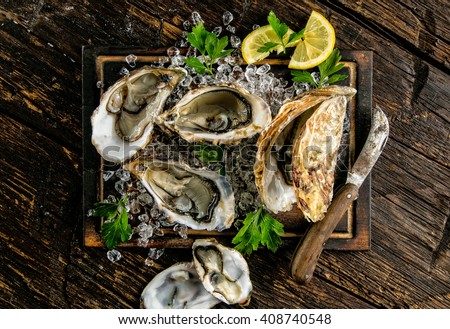 Oysters served on wooden board with ice drift