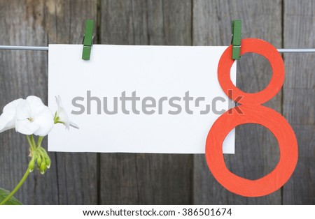 figure 8, paper envelope hang on clothespins in front of wooden background. International Women's Day. March 8, Happy Women's Day greeting message text