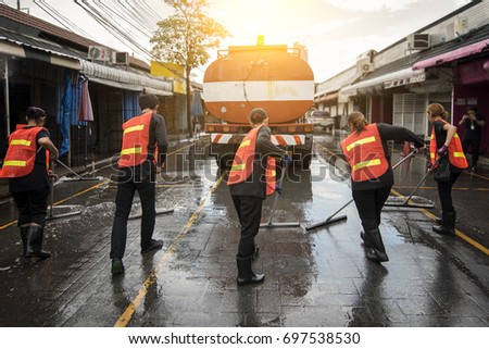 Road sweeper worker cleaning the street market with a broom.
