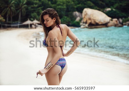 https://thumb1.shutterstock.com/display_pic_with_logo/3582083/565933597/stock-photo-beautiful-young-brunette-woman-in-blue-bikini-posing-on-the-beach-in-turning-booty-shows-ass-sexy-565933597.jpg
