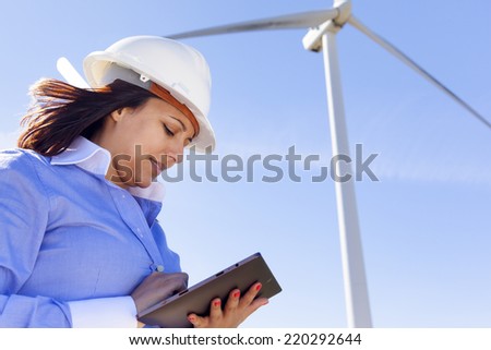Female engineer working with a tablet at wind farm