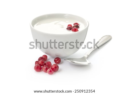 Yogurt in a bowl with cranberries and spoon isolated on white background
