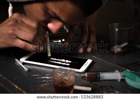 Disease concept. Drugs concept. Closeup picture of drug addict using drugs with help of mobile or smart phone. Drug addict man alone.