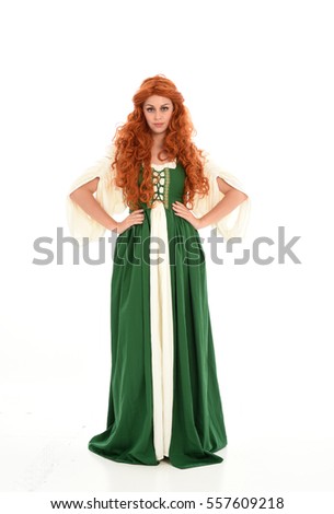 wodka na wesele - stock photo full length portrait of a curly red haired woman wearing green medieval gown standing pose 557609218