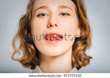 https://thumb1.shutterstock.com/display_pic_with_logo/3647660/475793158/stock-photo-beautiful-young-woman-licking-her-lips-flirting-close-up-isolated-on-a-gray-background-475793158.jpg