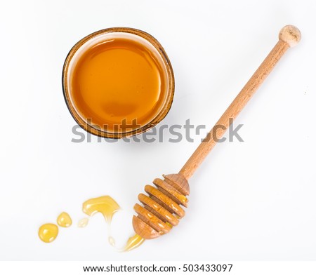 Honey dipper and fragrant honey into a bowl. Studio Photo
