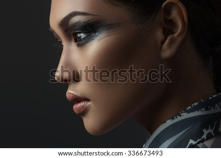 Portrait of beautiful asian girl with creative art make up. Picture taken in the studio on a black background.
