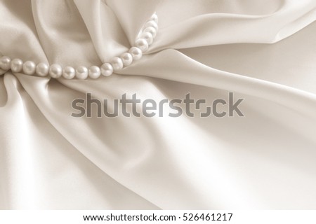 Elegant beige background with silk and pearls