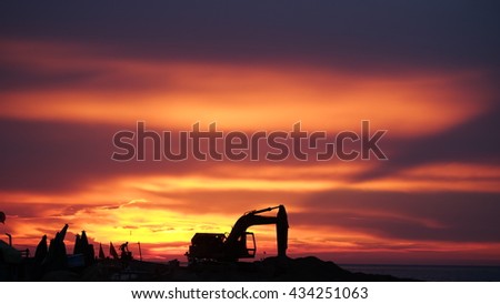 LY SON ISLAND, VIETNAM - JUNE 2016 : Beautiful sunset over boats on the sea of Ly Son island, Quang Ngai province, Vietnam. Flag and crane waving in the red sky. Revolution abstract. Sihouette.
