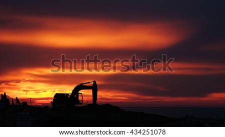 LY SON ISLAND, VIETNAM - JUNE 2016 : Beautiful sunset over boats on the sea of Ly Son island, Quang Ngai province, Vietnam. Flag and crane waving in the red sky. Revolution abstract. Sihouette.