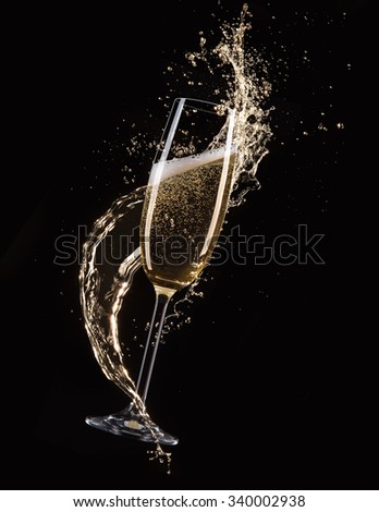 Glasses of champagne with splash, isolated on black