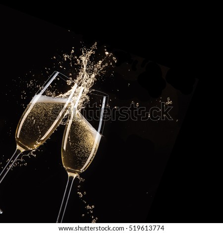 Glasses of champagne with splash, celebration theme.
