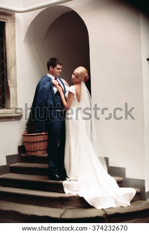 https://thumb1.shutterstock.com/display_pic_with_logo/3823586/374232670/stock-photo-beautiful-couple-bride-and-groom-posing-on-old-balcony-with-column-374232670.jpg