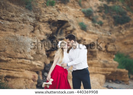 https://thumb1.shutterstock.com/display_pic_with_logo/3823586/440369908/stock-photo-romantic-loving-couple-walking-on-the-beach-with-rocks-and-stones-440369908.jpg
