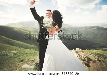 https://thumb1.shutterstock.com/display_pic_with_logo/3823586/518740120/stock-photo-beautiful-young-wedding-couple-making-selfie-on-the-background-of-mountains-518740120.jpg