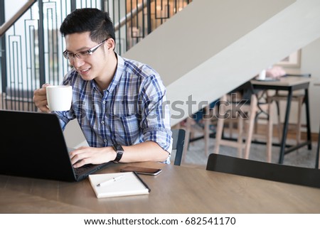 Asian Freelancer Man Using Laptop At Coffee Shop Or Student College Making Research On Asian Freelancer Man Using Laptop At Coffee Shop Or Student College Making Research On