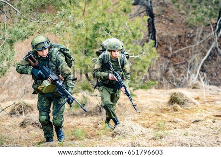 Soldiers of the Russian army march through the forest belt during a combat operation