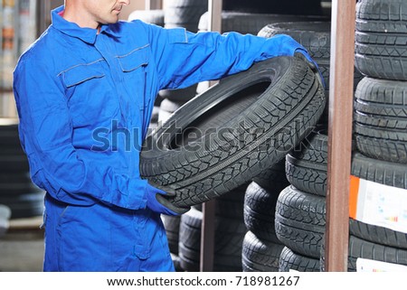 mechanic pulls tire from the tyre store warehouse