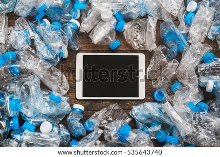 Recycling concept. Tablet wooden background around the transparent plastic bottles. The problem of ecology, environmental pollution.
