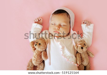 Sweet Little Newborn Baby Sleeping On The Blanket With His two bears Toy