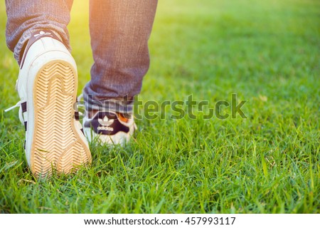 Bangkok,Thailand - July 25, 2016 : Woman walking with Adidas superstar shoes on green grass
