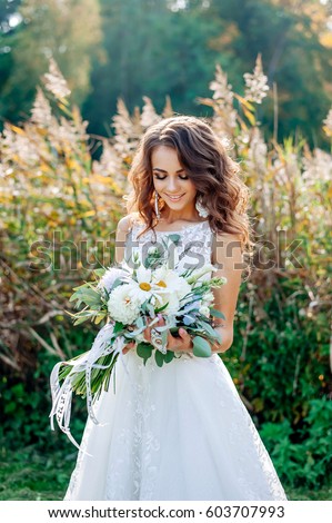https://thumb1.shutterstock.com/display_pic_with_logo/4030021/603707993/stock-photo-a-very-beautiful-bride-in-a-chic-wedding-dress-expensive-beautiful-accessories-look-down-603707993.jpg