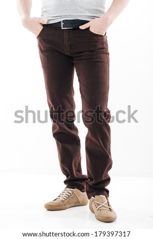 Man's feet in trousers and brown shoes close up, isolation on white