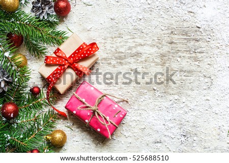 christmas background with fir tree, decorations and gift boxes covered with snow on white wooden background