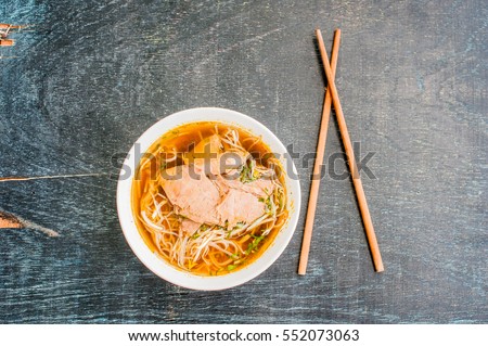 A bowl of Traditional Vietnamese beef soup Pho Bo at the dark old wooden background. ethnic meal. Vietnamese food concept
