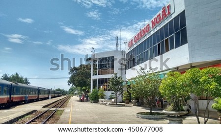 Editorial: Quang Ngai, Vietnam, 7th June 2016. Train of the 'State Railway of Vietnam' parked on tracks at the train station, some people waiting on the platform.