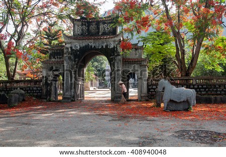 Ninh Binh, Vietnam, July 5, 2015 the ancient temple, Thai Vi Temple called, Ninh Binh, Vietnam, in the summer, many blooming flowers phoenix, cleaning woman