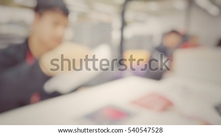 Blur abstract background air hostess ground staff working at check-in counter terminal.Blurry view receptionist work in front of computer for ticketing and loading baggage in international airport
