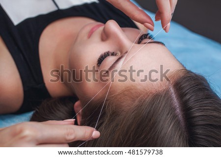 How do professionals thread eyebrows?