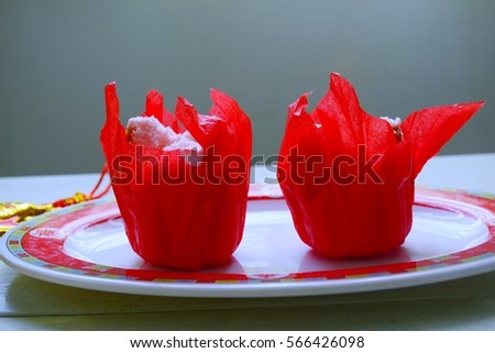 Chinese stream cake in red paper cup.Text on the plate is"fu(luck) lu(fortune)shou(long live)xi(joyful)
