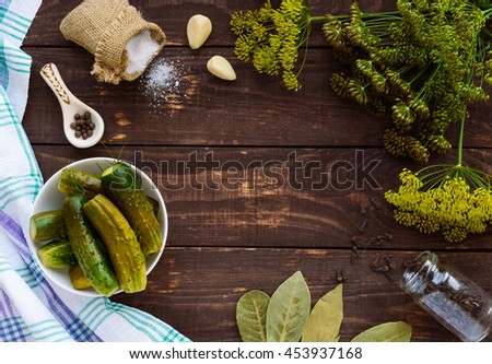 Salted cucumbers. Spices and herbs for making pickles. The top view of the wooden background