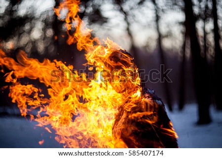 Burning clothing per person. A burning silhouette of a man. Image of a man on fire. Man on Fire. stuntman working on the fire. Day of Fire Performance of movement. Close-up portrait of a burning man.